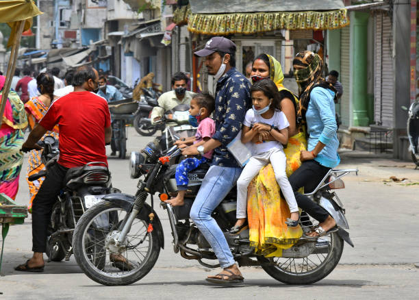 Beawar,  Rajasthan, India, April 19, 2021: Five person of a family ride on a bike at a market, amid surge in Coronavirus cases across the country, in Beawar. Rajasthan Government declared lockdown called 'Jan Anushasan Pakhwada' (Public Discipline Fortnight) for prevention of pandemic till 3 May