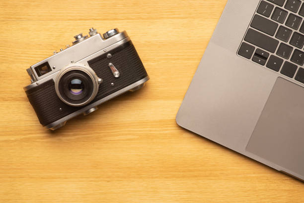 istock Workspace with laptop computer and camera on wooden table. Top view 1313476746