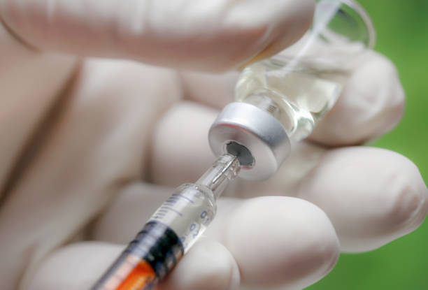 istock Vaccine vial with hand 1313479473