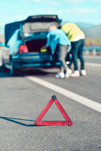 istock Couple Trying To Setup Emergency Signs During Vehicle Failure 1313480551