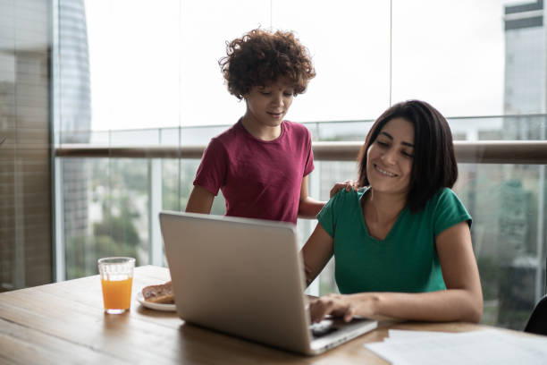 istock Boy talking to mother while she is working at home 1313480742