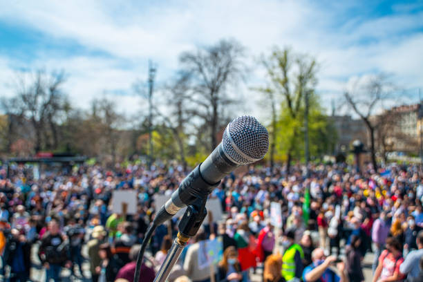 micrófono en el escenario con multitud borrosa - manifestación fotografías e imágenes de stock