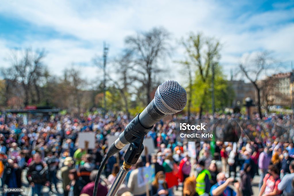 Microphone on the stage with blurry crowd Microphone on the stage with blurry crowd in the background Protest Stock Photo