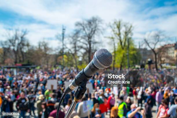Microphone On The Stage With Blurry Crowd Stock Photo - Download Image Now - Protest, Politics, Government