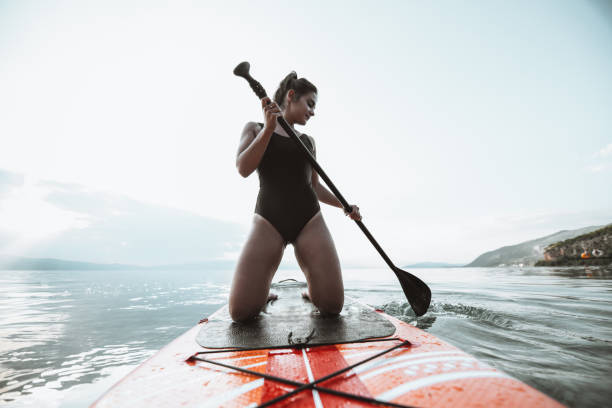 istock Female Kneeling While Rowing On Paddleboard During Summer Sunset 1313482051