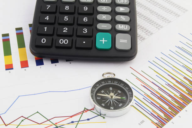 istock Calculator and compass on financial reports. 1313482222
