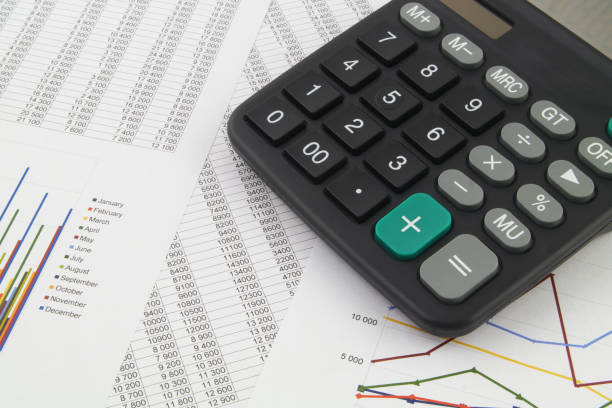 istock Calculator on financial reports with graphs close up. 1313482281