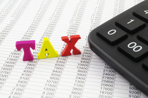 istock Word TAX and calculator on financial documents. 1313482300