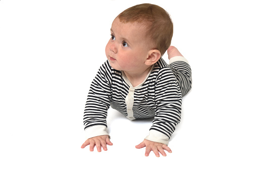 front view of a baby crawling on the floor looking away on white background