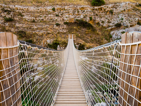 Impressive hanging bridge over Gravina canyon in Murgia National Park, Matera, Italy