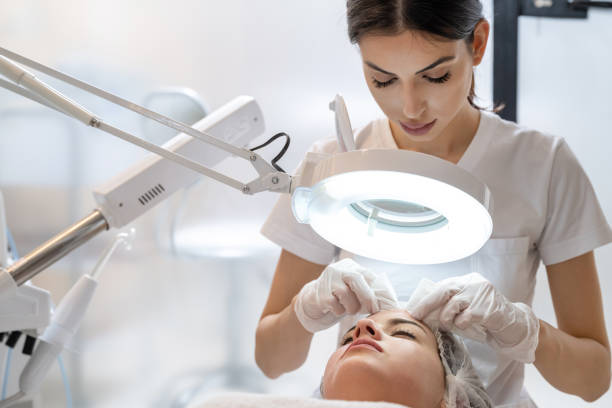 Skin treatment, beautician squeezing pimples from face of young female. Cleansing facial skin, beautician squeezed blackheads. Skin treatment, beautician squeezing pimples from face of young female. Cleansing facial skin, beautician squeezed blackheads. beautician stock pictures, royalty-free photos & images