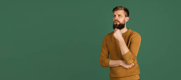 istock Caucasian man's portrait isolated over green studio background with copyspace 1313489083