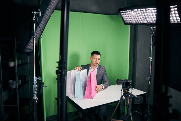 istock Handsome young man with purchases recording video for blog 1313489191
