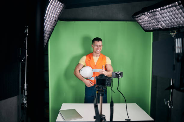 Joyful male builder recording video for construction blog