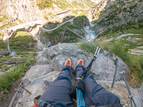 Wide angle view of sporty man climbing in summer on Via Ferrata in Switzerland