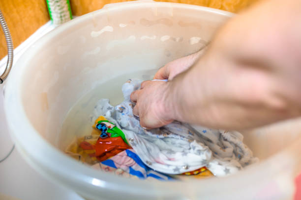 istock a man washes baby clothes in a basin by hand 1313489694