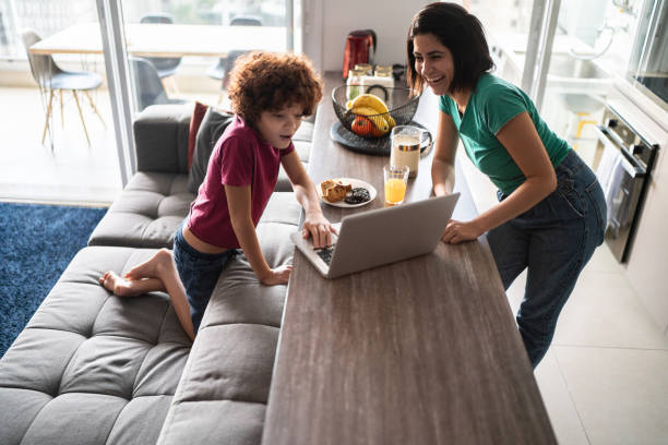 istock Mother and son using laptop at home 1313492097