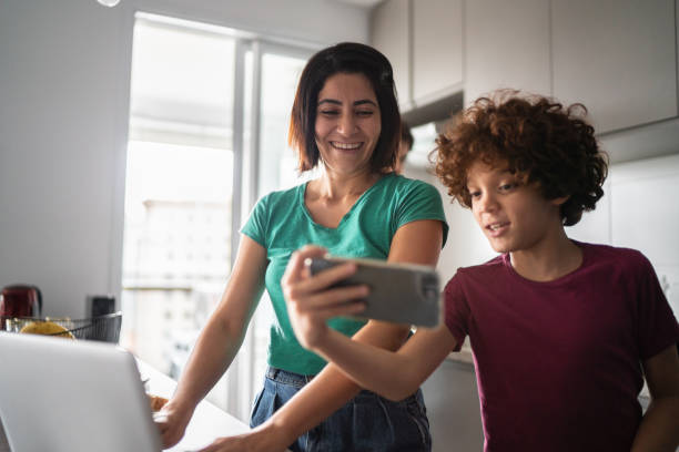 istock Mother and son doing a video call on smartphone at home 1313492179