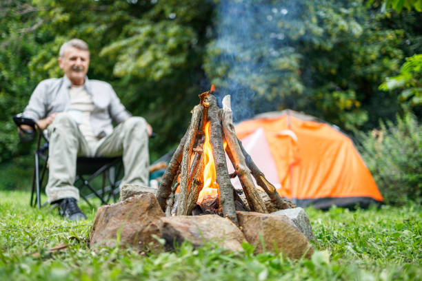 istock Man sitting by his camp and looking at the campfire 1313493052