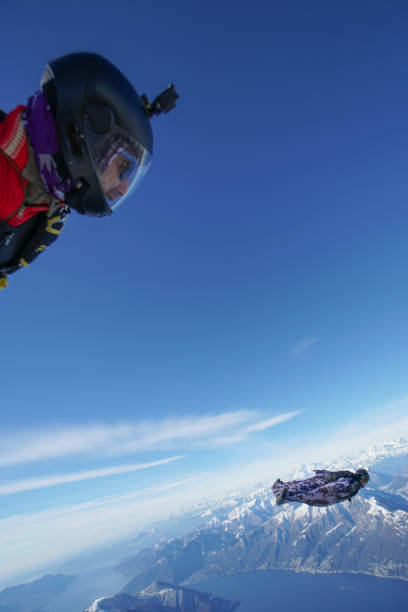 istock Wingsuit fliers soar above Swiss mountain landscape 1313493284