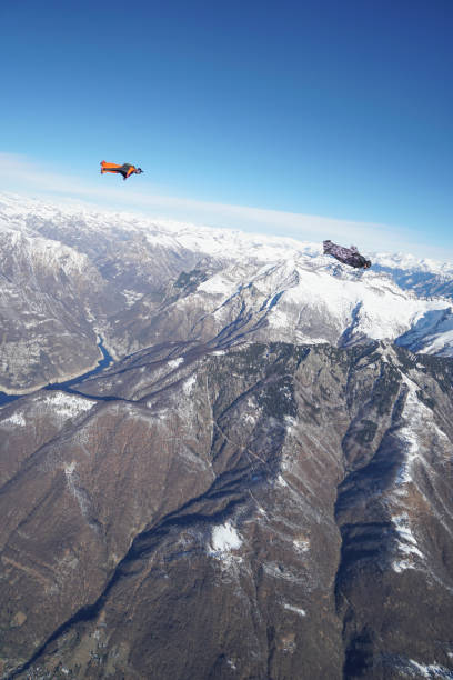 istock Wingsuit fliers soar above Swiss mountain landscape 1313493343