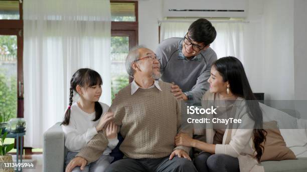 Asian Elderly Senior Male Grandpa Sitting At Sofa Couch At Home Living Room On Quarantine In Concept Healthcare Chronic Health Issue Or Low Back Pain In Retired Older People With Family Stock Photo - Download Image Now