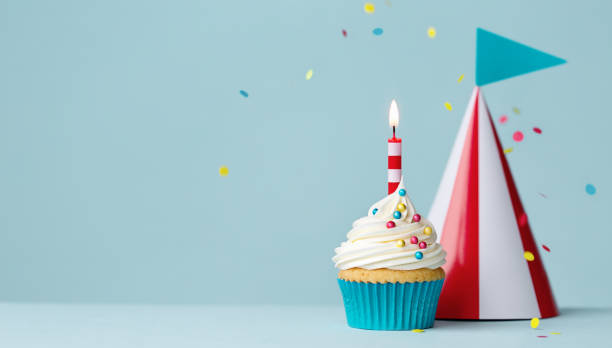istock Birthday cupcake with red and white striped party hat 1313496958