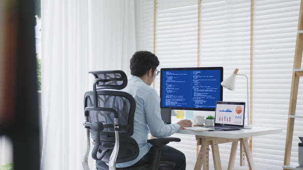 istock Back rear view of young asian man, freelance data scientist work remotely at home coding programing on Big data mining, AI data engineering, IT Technician Works on Artificial Intelligence Project. 1313498214