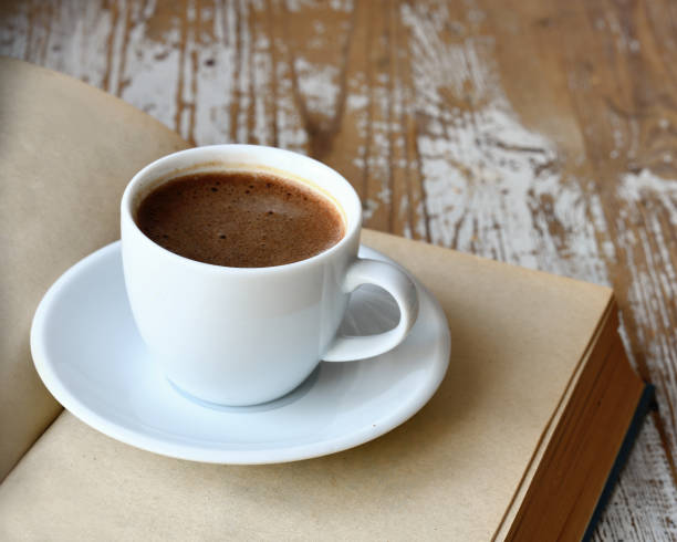 istock Cup of coffee and a book on the table. 1313499535