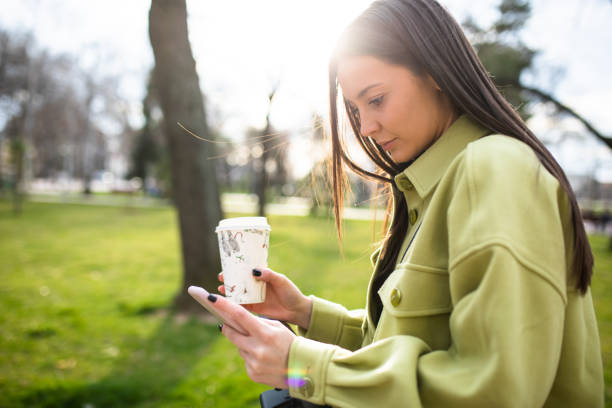 istock An attractive young woman texting in a park 1313499714