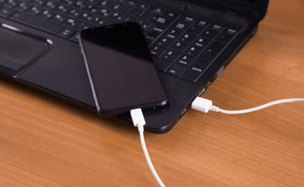 istock Wooden background isolated charger, smartphone and computer. 1313500986