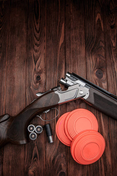 Clay target plates for shooting with rifle on wooden background.