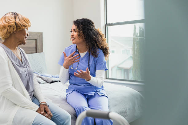 istock Nurse gestures as she and senior chat during home visit 1313503817