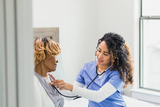 istock Nurse listens to patient's lungs during home visit 1313503981