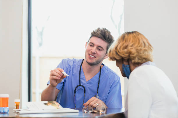 istock Male nurse takes patient's temperature during home visit 1313504040