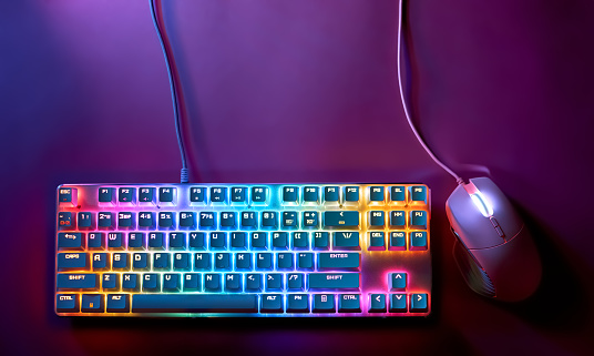 Stylish gaming mouse and keyboard with rainbow lighting. Mechanical keyboard and mouse with backlight, top view. The concept of esports and gaming.