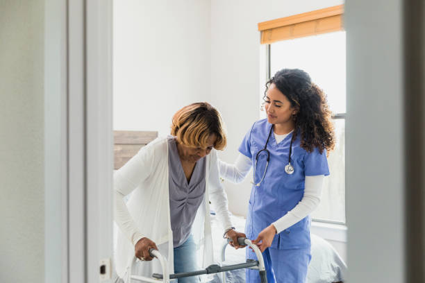 istock Female nurse helps senior patient use mobility walker 1313504764