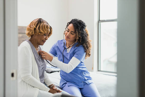 istock Nurse sits beside patient to check heart with stethoscope 1313504771