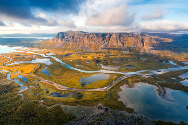 Beautiful, wild arctic valley viewed from mountain top in epic early morning light. Remote Rapa river valley from the top of Skierfe in Sarek national park in Swedish Lapland. Autumn colors. stock photo