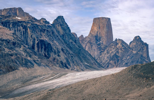 kultowa granitowa skała mt.asgard góruje nad lodowcem turner w odległej arktycznej dolinie przełęczy akshayuk, wyspa baffin, kanada. - baffin island zdjęcia i obrazy z banku zdjęć