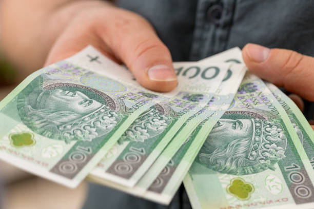 argent polonais, cent billets zlotys tenus dans les mains - beak buying currency exchanging photos et images de collection