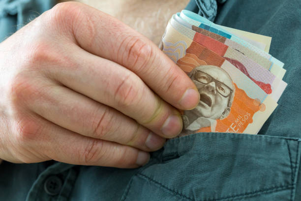 o homem pega um pacote de pesos colombianos do bolso da camisa - beak buying currency exchanging - fotografias e filmes do acervo