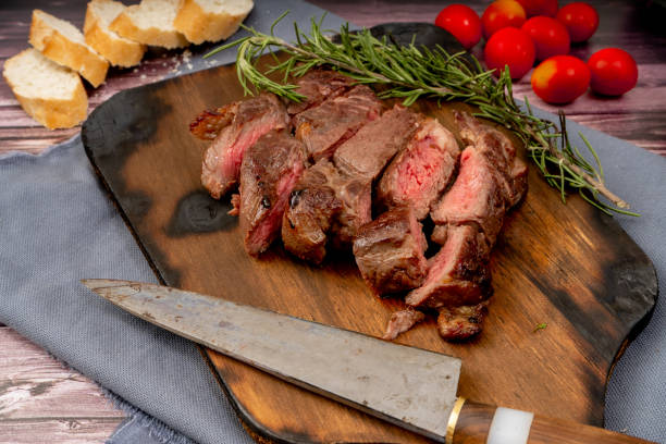 churrasco de viande coupée en morceaux sur une planche de bois dans un cadre rustique. vue irréelle - steak argentina food silverware photos et images de collection