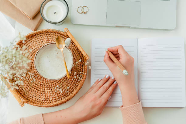 istock Home office, work, female hands, cappuccino, wicker tray, spring, home decor, laptop, notebook. Cozy. 1313514270