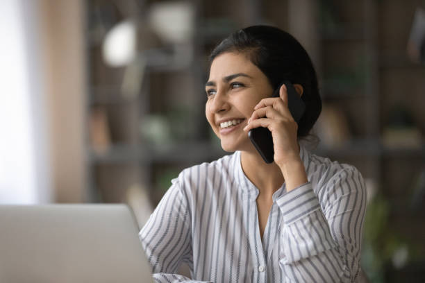 istock Smiling Indian woman talk on cellphone online 1313516066