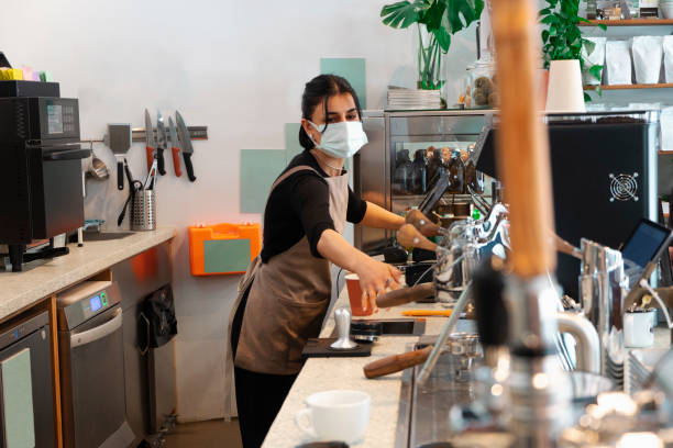 istock Barista wearing a mask makes coffee 1313517072