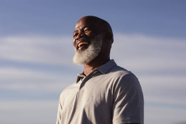 istock Senior african american man smiling while standing on the beach 1313520026