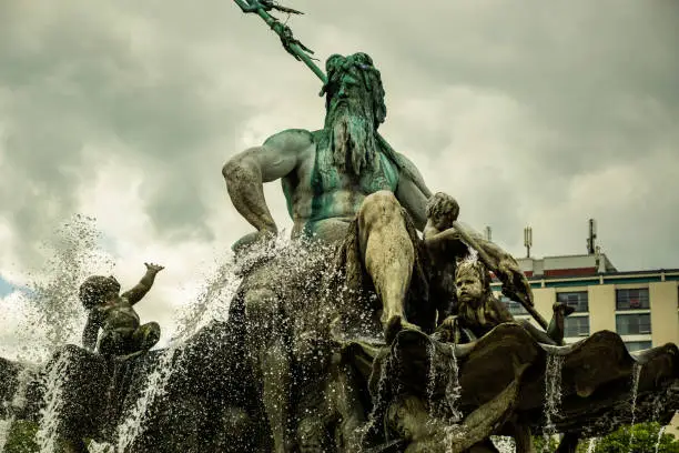 Neptune fountain (Neptunbrunnen) on Alexanderplatz, springtime and cloudy weather.