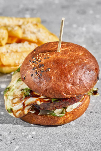 istock cheese burger with sunlight on stone background. 1313521558