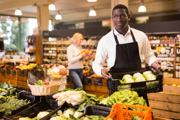 istock Grocery worker arranging vegetables on counter 1313524913
